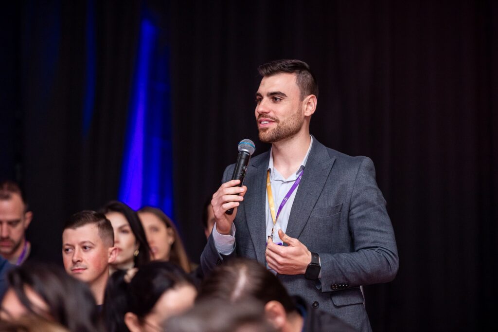Vinícius Melo palestrante de educação financeira com microfone em evento